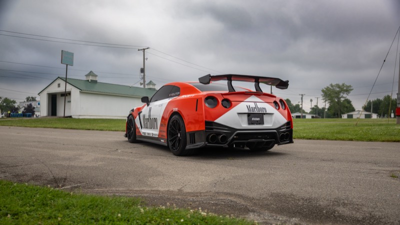 1200HP GTR in a red and white racing livery, rear three-quarter view